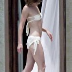 Pic of Milla Jovovich topless but covered on the beach in Los Cabos