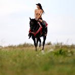 Pic of Melisa Mendiny - Melisa Mendiny rides her strong black horse outdoors wearing nothing but pants.