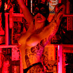 Pic of Tattooed cat woman Michelle Aston in black latex mask and boots plays with herself in red light