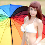 Pic of Fascinating redhead nymph with impressive tits posing with a big gaudy umbrella outdoors.