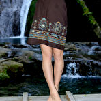 Pic of Cute Nensi B showcasing her delightfully petite body against a refreshing view of the cascading waterfalls.