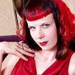 Pic of Pale skinned redhead Szandora strips out of her long red dress and exposes her nude body