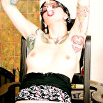 Pic of Inked brunette Bella Vendetta in glasses inserts glass dildo in her pink pierced pussy