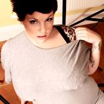 Pic of Tattooed brunette Dors Feline with massively huge tits takes off her t-shirt and bra