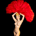 Pic of Miss Miranda poses in a burlesque costume and feather fans