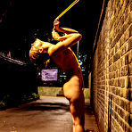 Pic of Naked teen is restrained to a brick wall with yellow rope at night