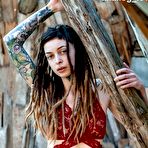 Pic of Tattooed female Cutz sports dreadlocks while showing her tiny tits