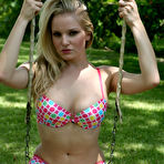Pic of Young blonde girl starts to take off her bikini top on a swingset