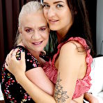Pic of Old and young lesbians kiss before getting naked for sex on a sofa