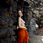 Pic of Young brunette Keira Blue models completely naked against a rock face